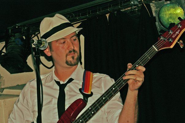 Bassist in a fedora under stage lights