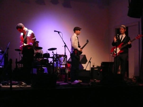 A live band on a purple-lit stage