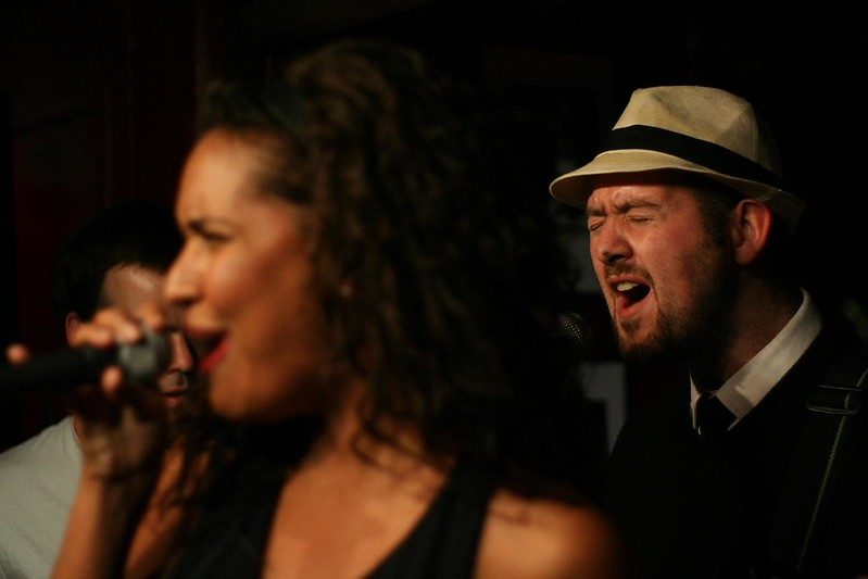 Singer and bassist in close-up, mid-song
