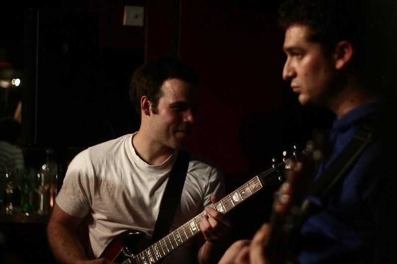 Two guitarists sharing a moment on stage