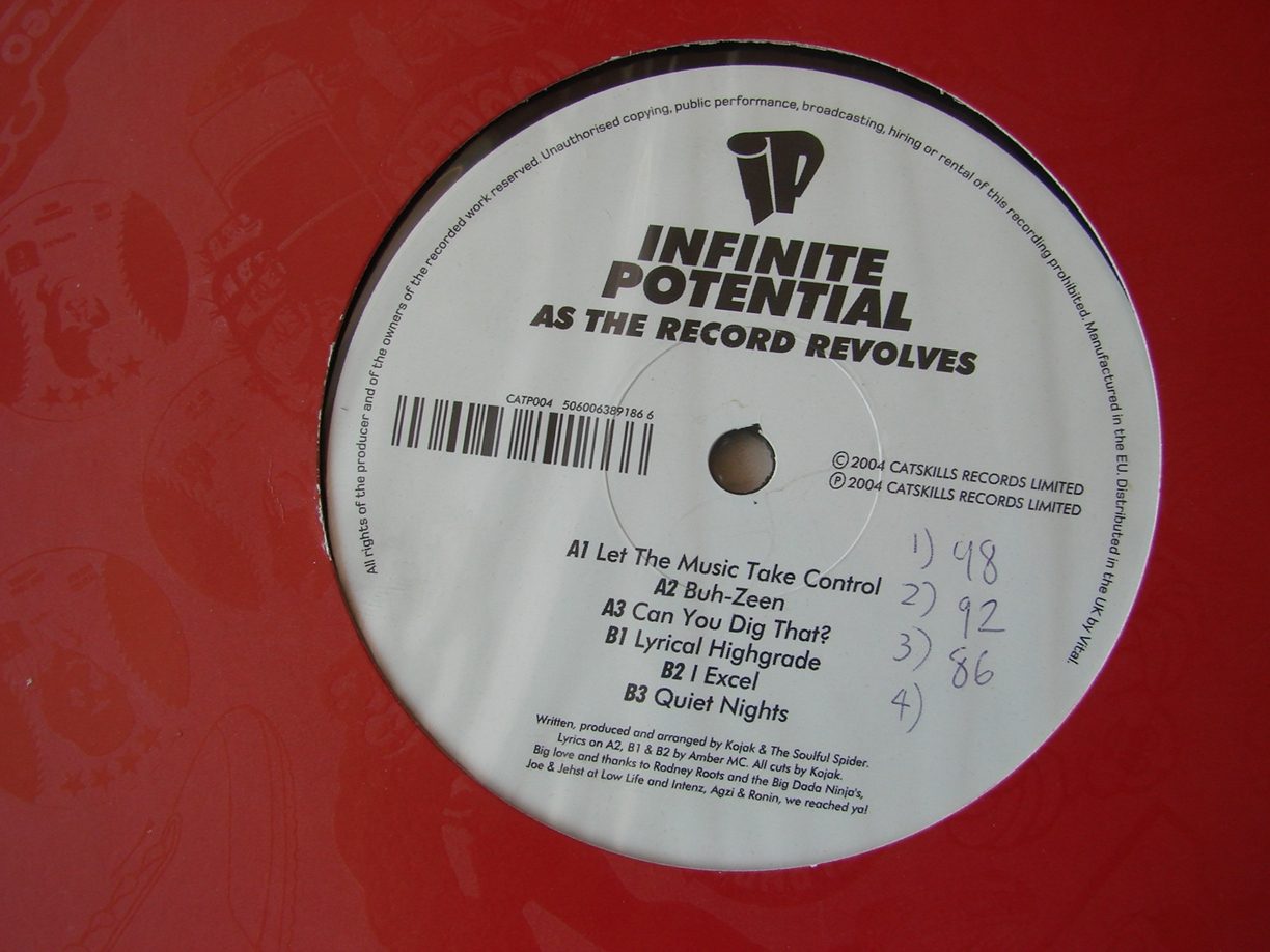 The side A label of As The Record Revolves on red vinyl sleeve