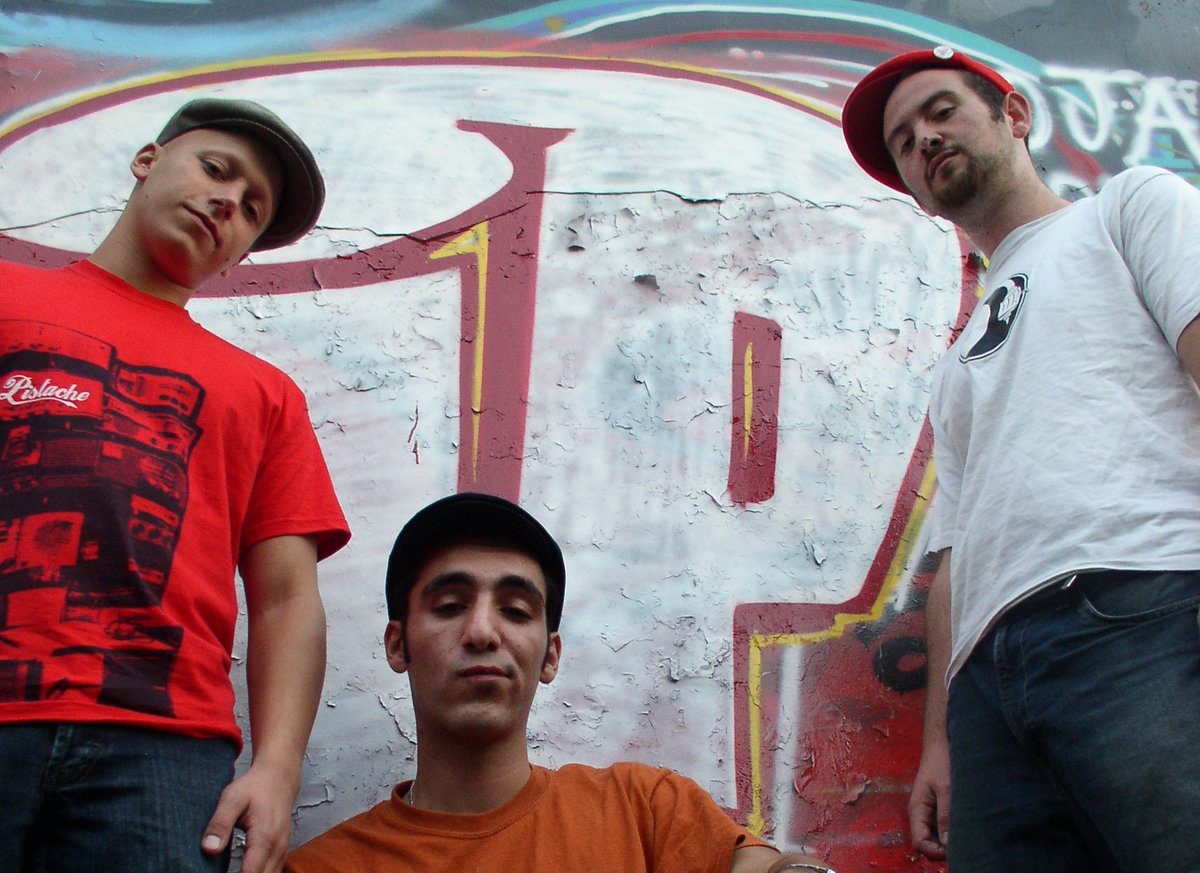 Three members of Infinite Potential in front of a graffiti wall
