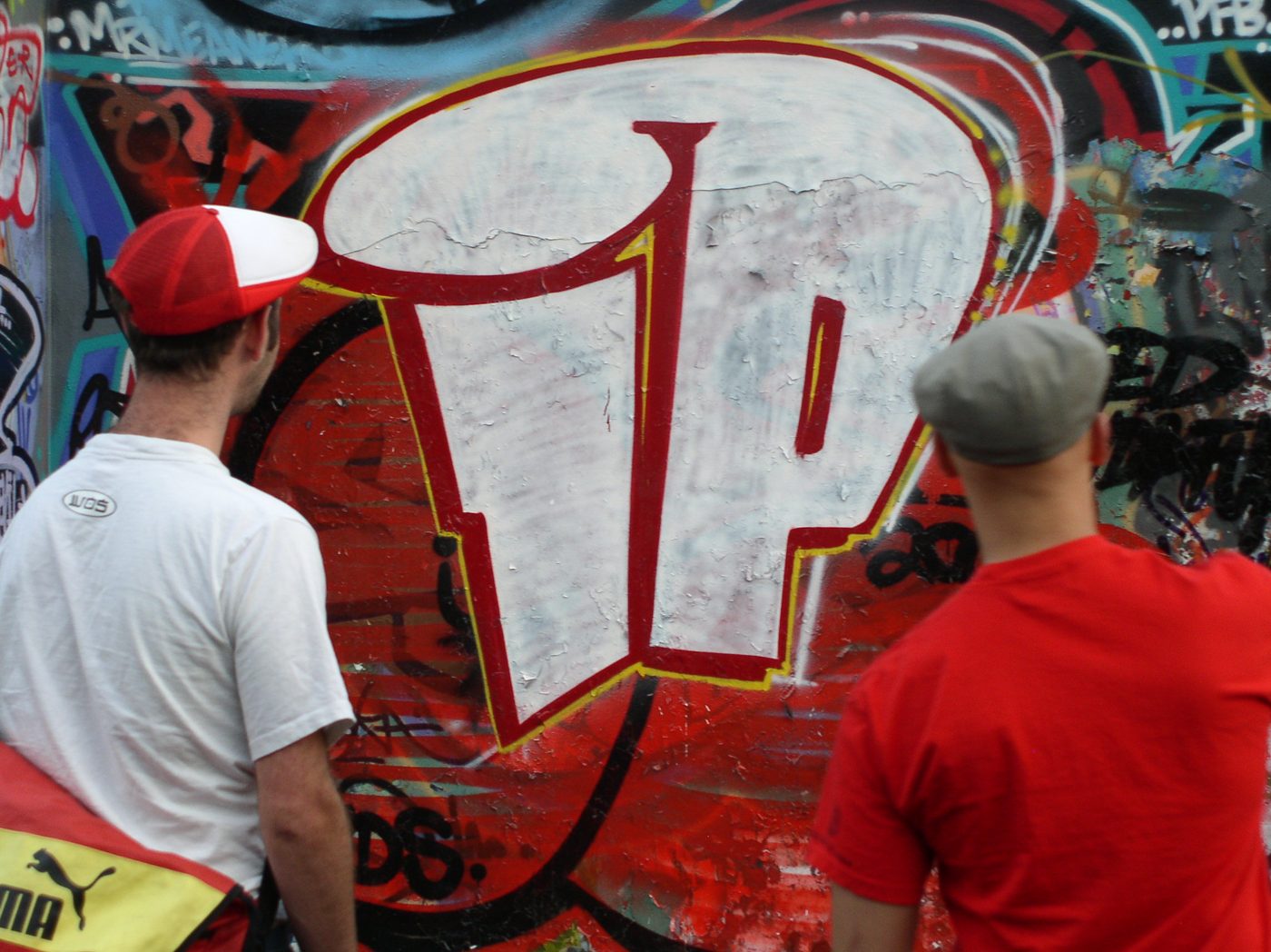 Two members seen from behind, looking at the IP graffiti