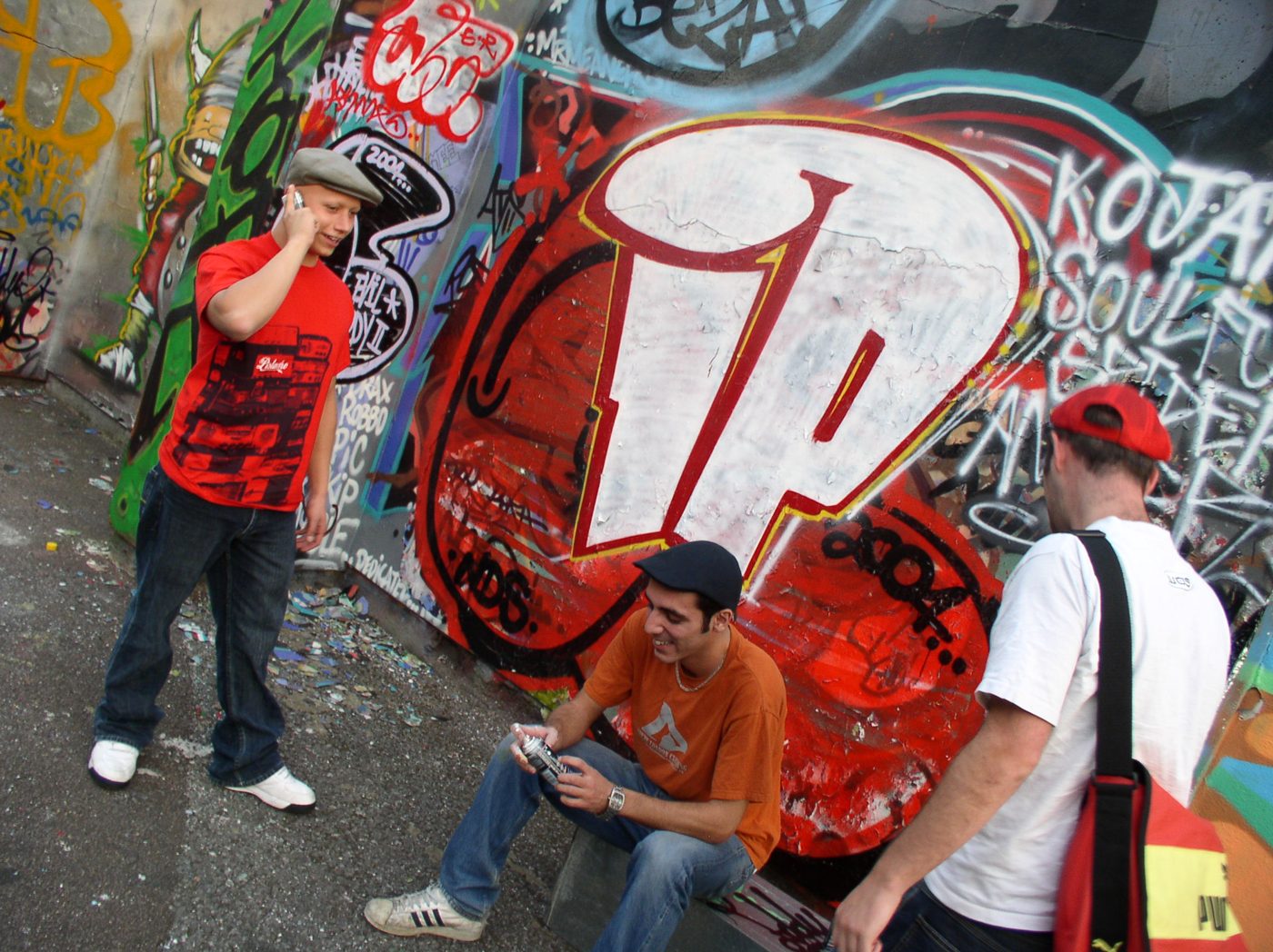 One member on the phone, one seated, one walking past the IP wall